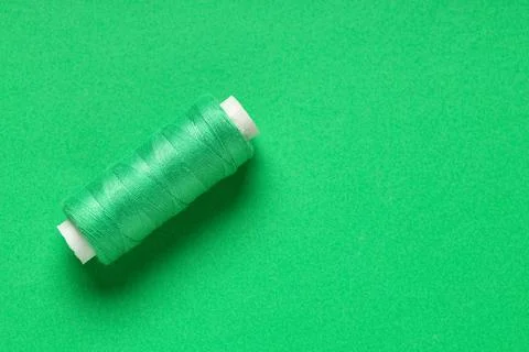 Spool of thread on green background Stock Photos