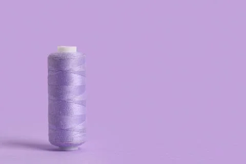 Spool of thread on lilac background Stock Photos