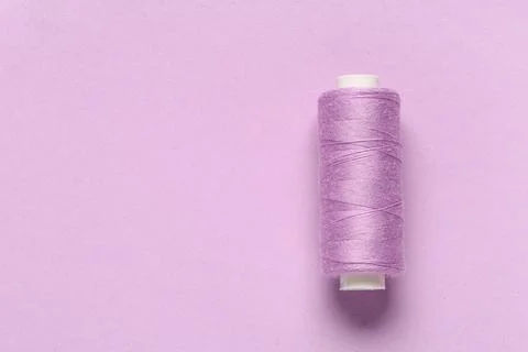 Spool of thread on lilac background Stock Photos