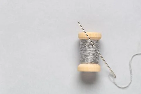 Spool of thread with needle on grey background Stock Photos