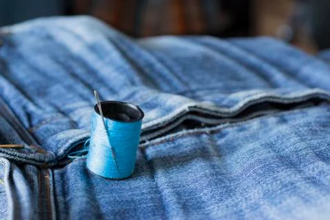 The spool of thread, needle, old jeans Stock-Fotos