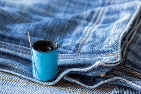 The spool of thread, needle, old jeans Stock Photos