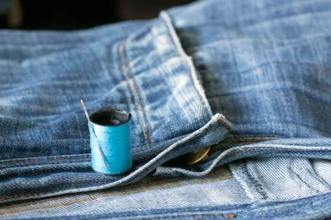 The spool of thread, needle, old jeans Foto stock