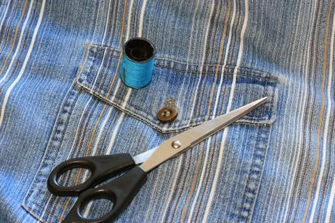 The spool of thread, needle, old jeans Foto stock