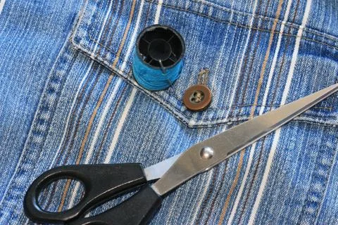 The spool of thread, needle, old jeans Fotos de archivo