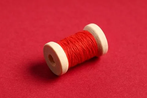 Spool of thread on red background Stock Photos