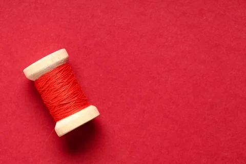 Spool of thread on red background Stock Photos