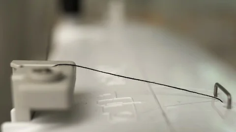 The spool of thread on the sewing machine is unwound in the process of sewing Stock Footage 114619971