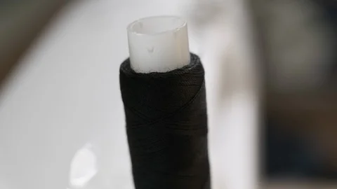 The spool of thread on the sewing machine is unwound in the process of sewing Stock Footage 114620502