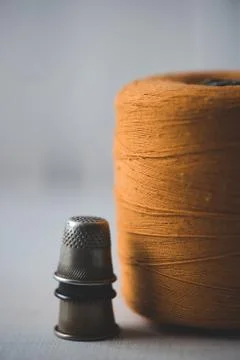 Spool of thread with thimbles staying on table closeup. Handmade. 스톡 사진