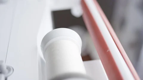 Spool of thread unwinding as sewing machine runs Stock Footage 128312521