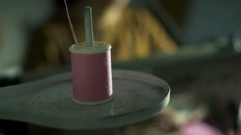 Spool thread while female dressmaker is working at sewing machine. Stock Footage 104020835