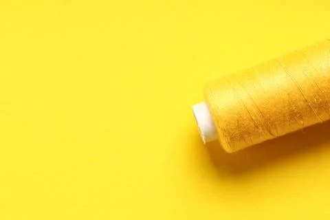 Spool of thread on yellow background Stock Photos