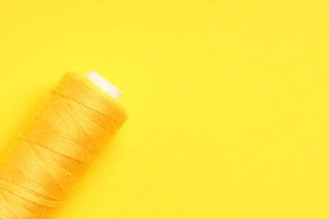 Spool of thread on yellow background Stock Photos