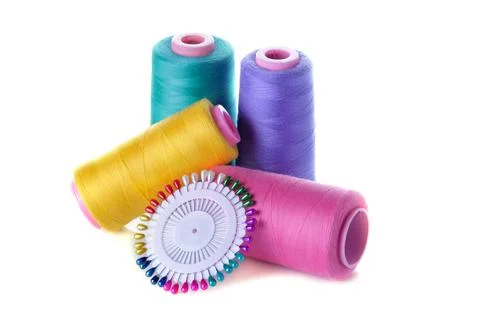 A spool with threads colored and pins on a white isolated background. accesso Stock Photos
