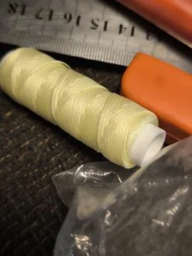 Spool of yellow thread with ruler and plastic tools. Stock Photos
