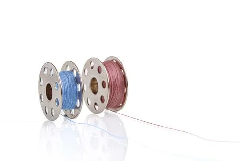 Spools of blue and pink thread on a white background Stock Photos