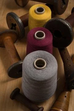 Spools of Color Thread Aligned Vertically with Wooden Spools Stock Photos