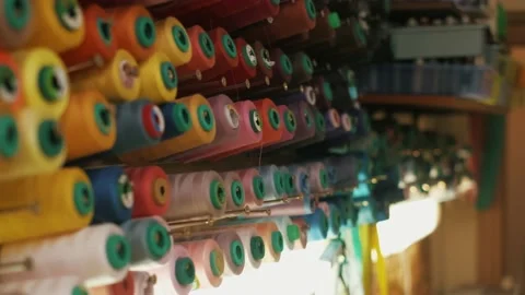Spools of colored thread on a vertical stand. Close-up hand removes spools of Video stock 152098077