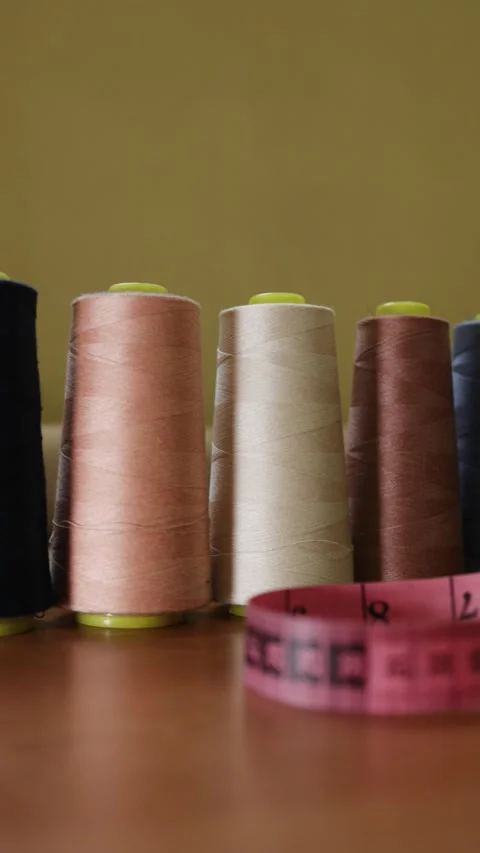 Spools of colorful sewing thread, showcasing various shades, neatly arranged on Stock Footage 300204744