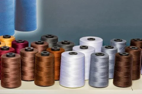 Spools of colorful thread in various shades create a lively display in a sewi Stock Photos