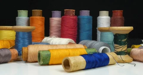 Spools with colour threads rotates on black background. Cinema 4K 60fps video Stock Footage 311833098