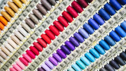 Spools of different colored threads on display in a sewing and crafts shop Stock Photos