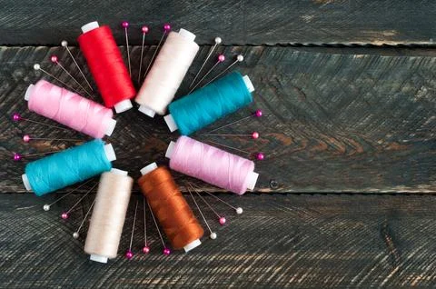 Spools with different colors of thread and pins on old wooden background. S.. 写真素材
