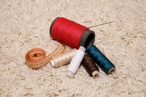 Spools of different colors of thread, needle, meter lie on a white background Stock Photos