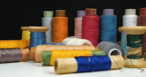 Spools with multi-colored threads on black background, close-up shot Stock Footage 310251124