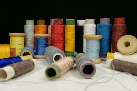 Spools with multi-colored threads on black background Foto stock