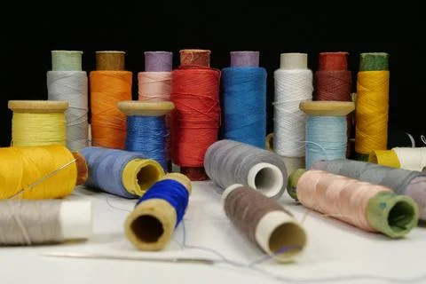Spools with multi-colored threads on black background, close-up shot Stockfoto's