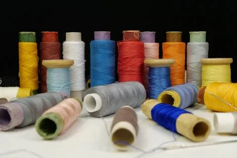 Spools with multi-colored threads on black background, close-up shot 库存照片
