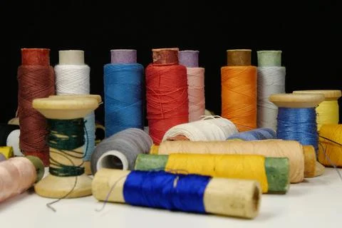 Spools with multi-colored threads on black background, close-up shot 库存照片