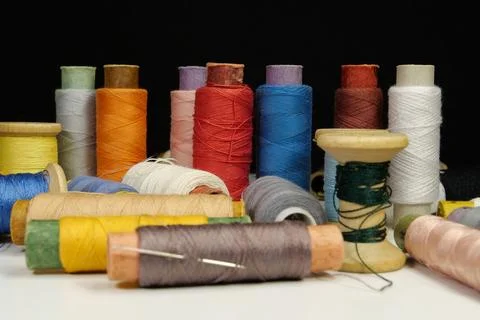 Spools with multi-colored threads on black background, close-up shot Foto stock