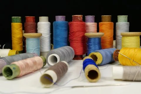 Spools with multi-colored threads on black background, close-up shot Stockfoto's