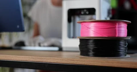 Spools with multicolored plastic for 3D printer on desktop closeup 4k movie slow Video stock 231365645