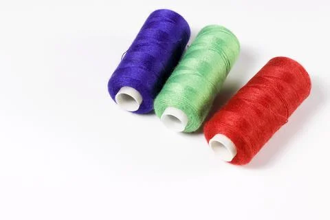 Spools with sewing threads - red, blue, green. Stock Photos