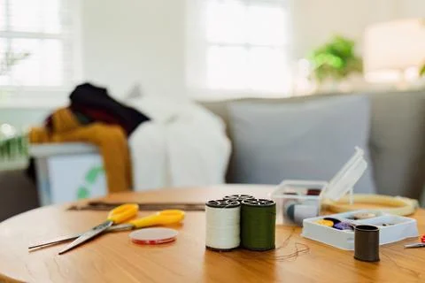 Spools of thread and basic sewing tools including pins, needle, a thimble, and Stock Photos