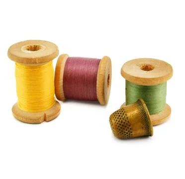 Spools of thread and thimble Spools of thread and thimble isolated on a wh... Stock Photos