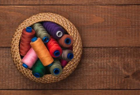 Spools of thread in a basket. Hobby set. Flat lay. Stock Photos