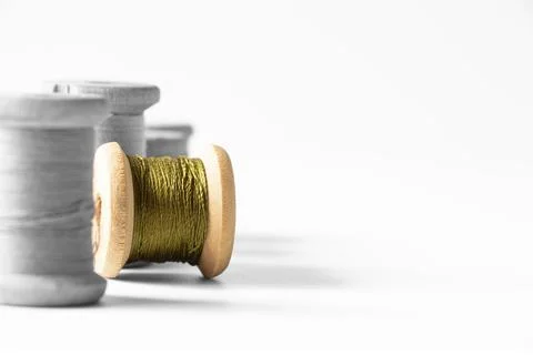 Spools of thread black and white and one spool of green thread colored, threa Stock Photos