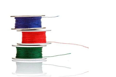 Spools of thread in blue, red, green colors on a white background Foto stock