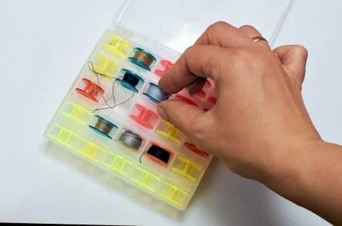 Spools of thread in a box. Garbage craft. Woman's hand pulls the thread out o Stock Photos
