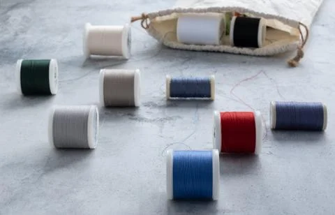 Spools of thread of different colors rolled out of the half-ton bag on the li 스톡 사진