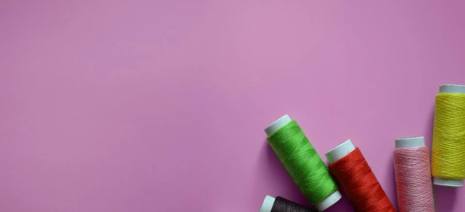 Spools of thread on a pink background, a banner for an atelier, tailoring, .. Stock Photos