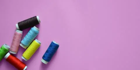 Spools of thread on a pink background, photos for a sewing workshop, tailor.. Stock Photos