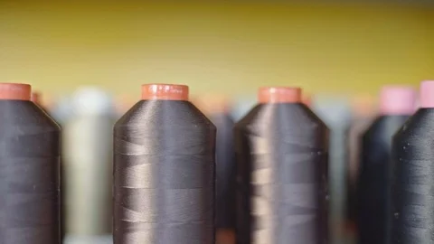 Spools of thread for sewing shoes in dark colors stand on a shelf. Stock Footage 123413903