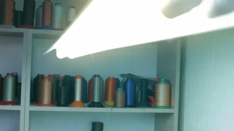 Spools of thread for sewing shoes in dark colors stand on a shelf Stock Footage 170551502
