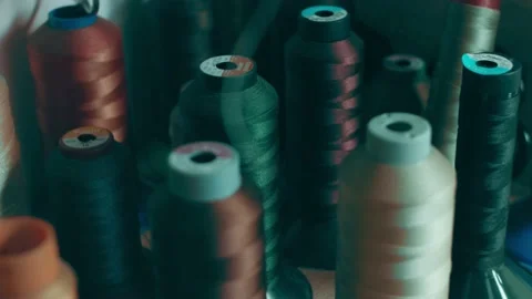 Spools of thread for sewing shoes in dark colors stand on a shelf Stock Footage 232616220
